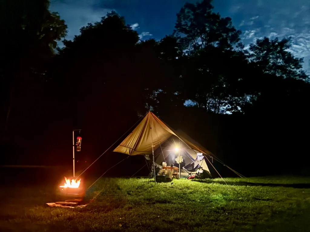 夜のMOUNT NIKIキャンプ場。焚き火と月明かりの夜空