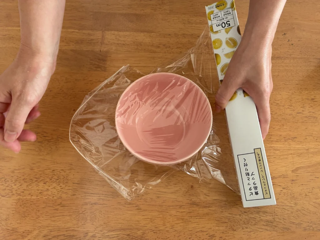 カインズの「ピタッと貼り付く食品ラップ」のラップを器にかけているところ。