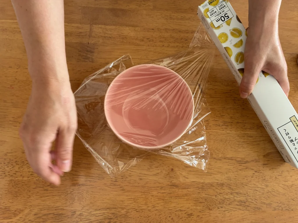 カインズの「ピタッと貼り付く食品ラップ」のラップをカットしているところ。