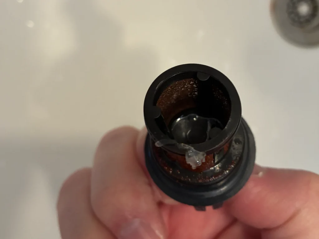 給水ストレーナーのメッシュにサビ汚れがびっしり詰まった状態（清掃前の斜め上からのアングル）