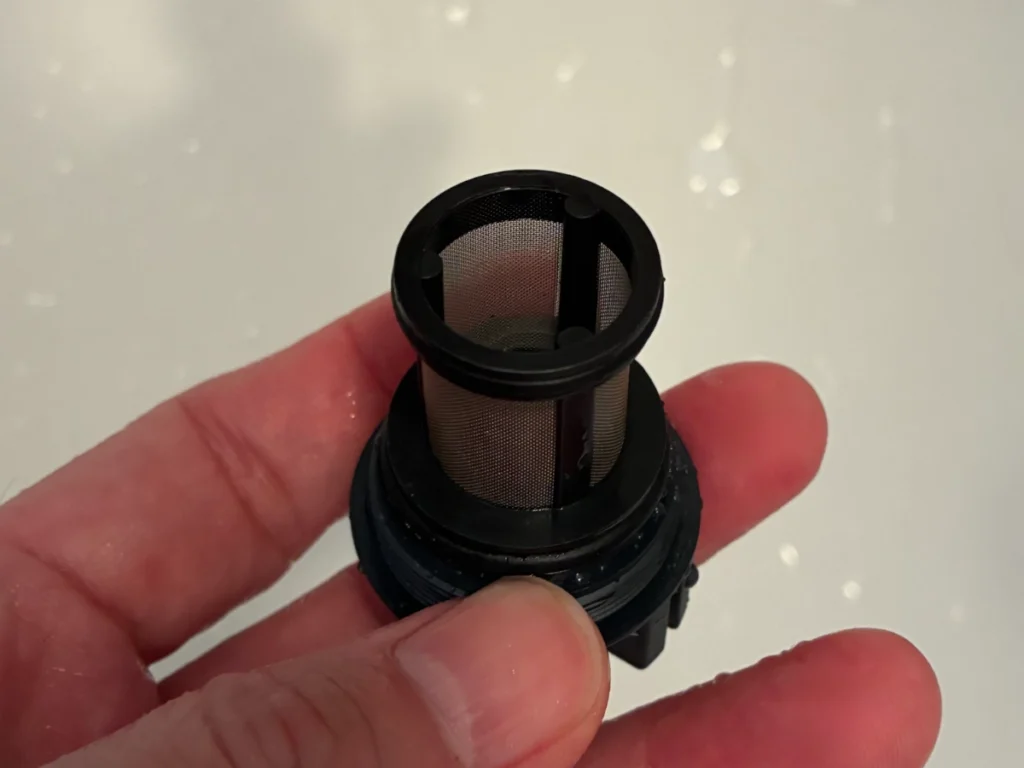 清掃後の給水ストレーナー（メッシュ越しに向こう側が見える状態。真横からの斜め上からのアングル）