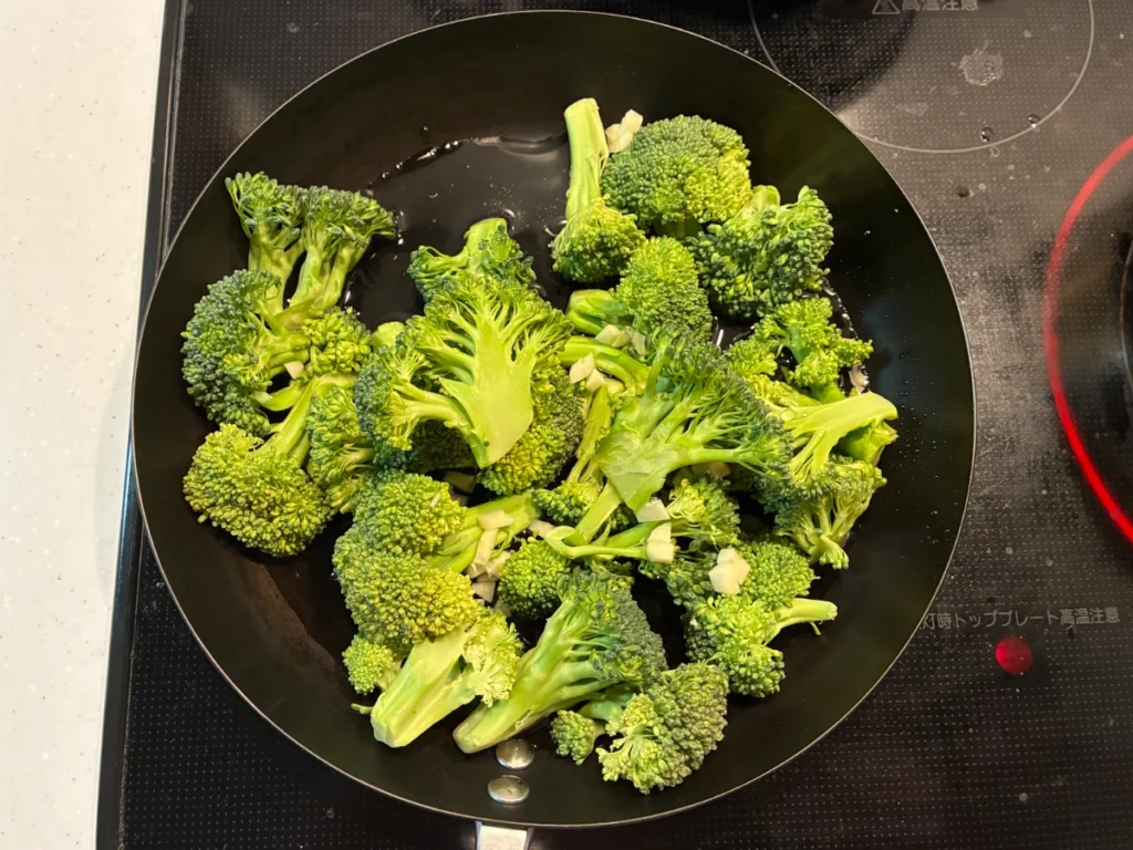 コストコのブロッコリーフローレットを袋から出してフライパンで調理している写真