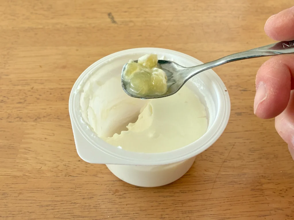 コストコで購入したOIKOSヨーグルト（アップル）の底に入っている果肉部をスプーンですくっているところ
