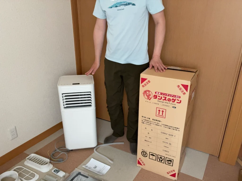 180cmの人と並べてタンスのゲンのスポットクーラー本体と梱包箱のサイズ感を比較した写真