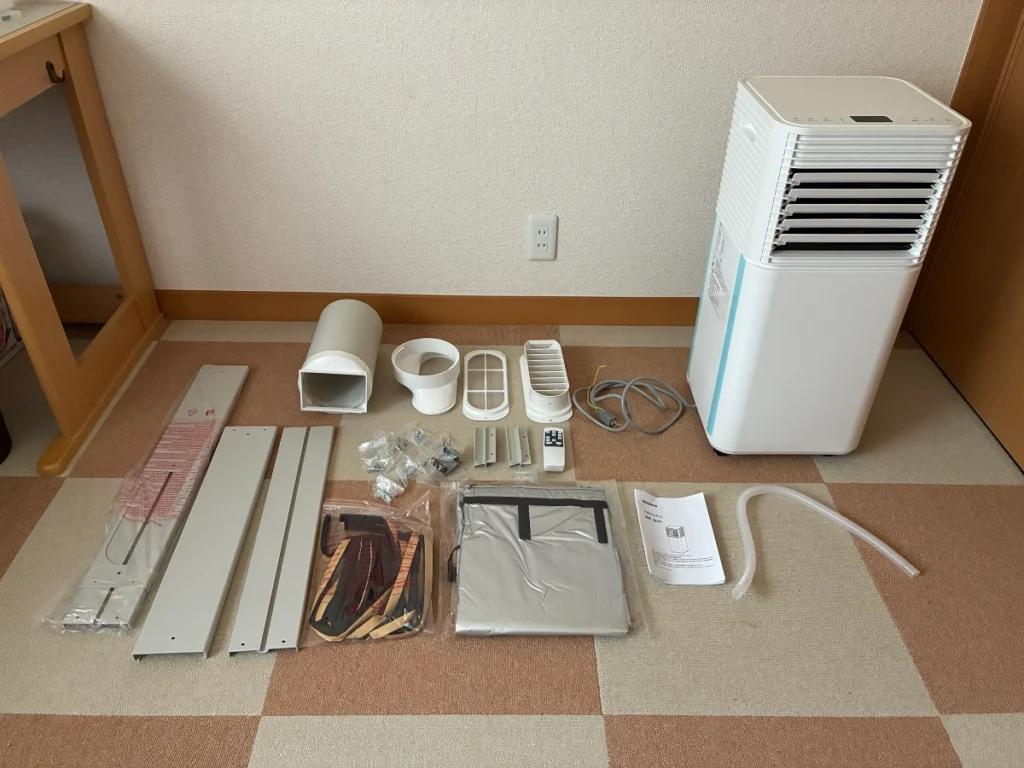 タンスのゲンのスポットクーラー本体と窓パネル、排熱ダクトなどの付属品を並べた写真