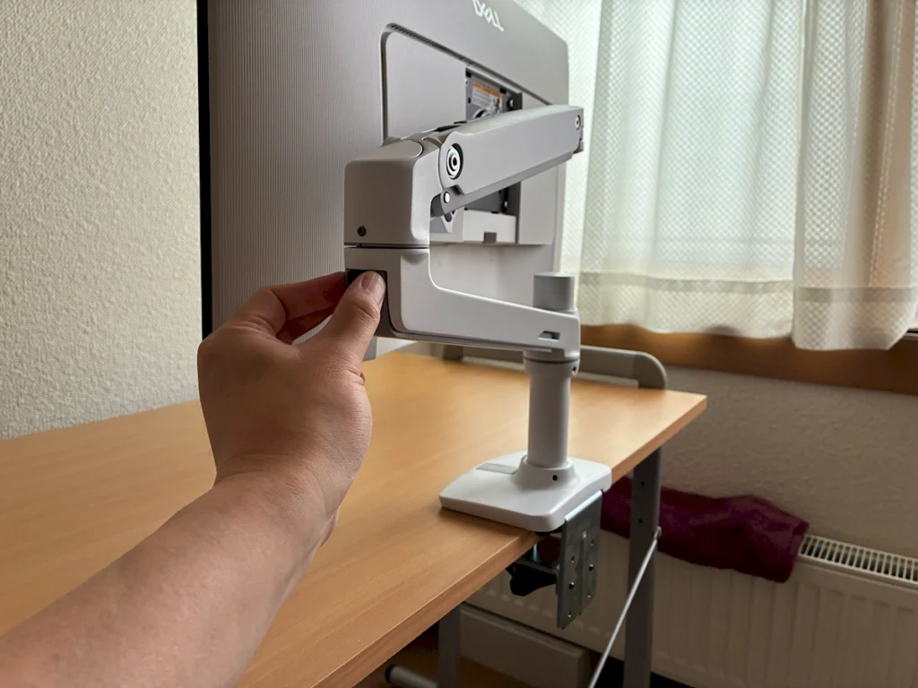 エルゴトロンLXのアームにケーブルカバーを開く様子