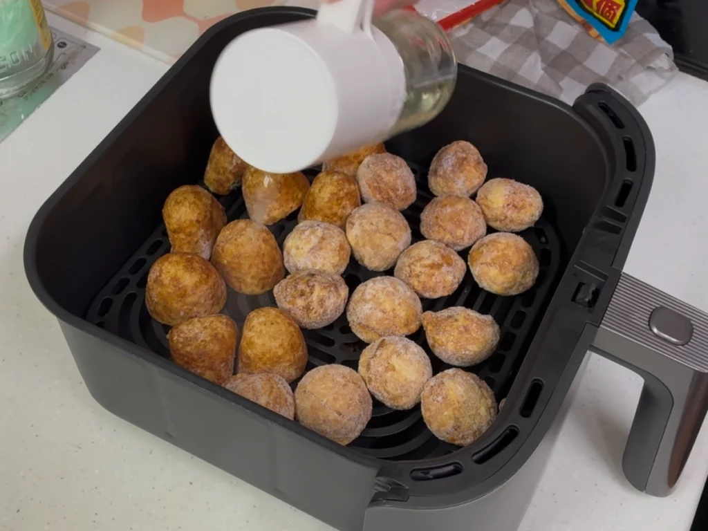 冷凍たこ焼きへオイルスプレーを吹きかけているところ