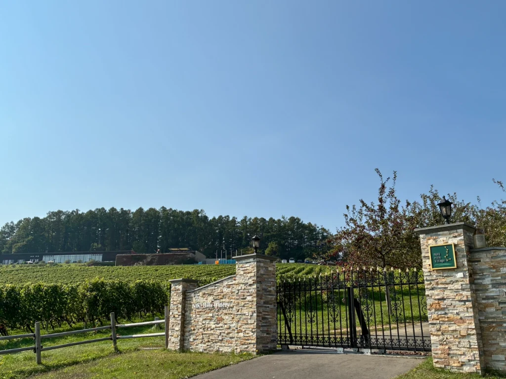 NIKI Hills Wineryの石造りの門と広がるワイン用ぶどう畑