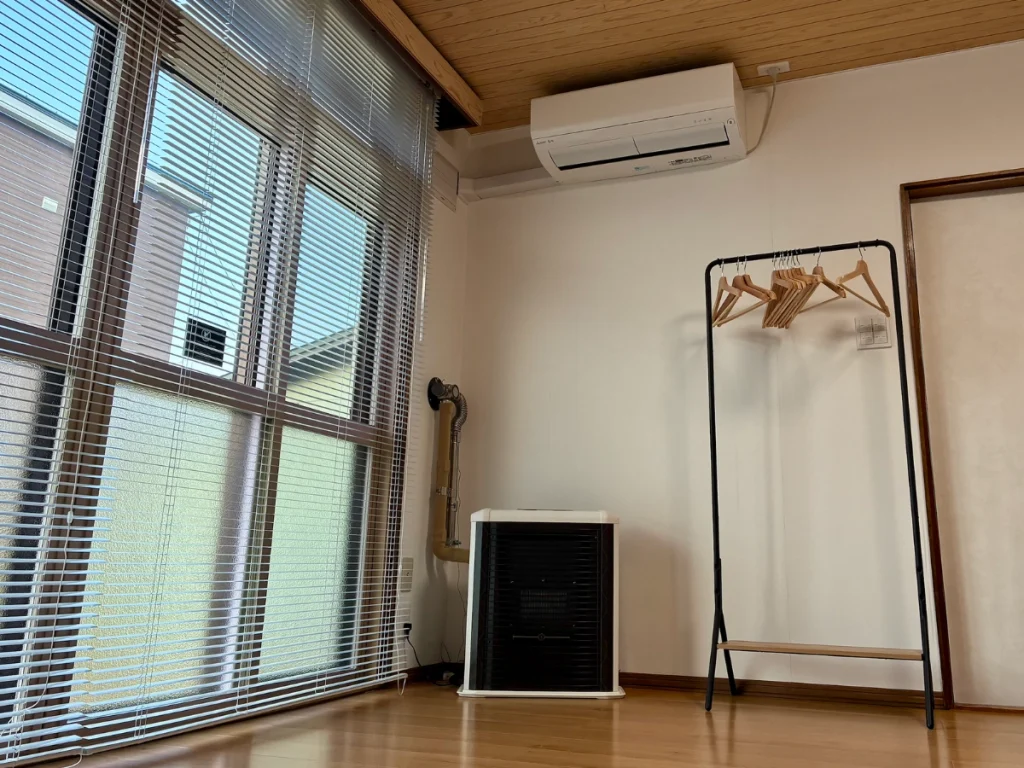 Yoichi Niki Retreatのリビングに設置されたエアコンとFF式灯油ストーブ